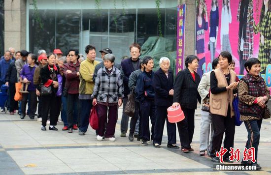 圖為10月28日，在江西九江市一家羊絨皮草服裝服飾博覽會(huì)現(xiàn)場(chǎng)，老人們正在頂著寒風(fēng)排隊(duì)等待領(lǐng)取10元代金劵。