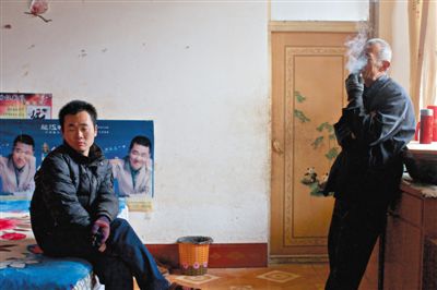 父親抽煙，兒子不語。逃跑的越南新娘，給袁迎賓父子帶來的是失落。新京報記者 周崗峰 攝