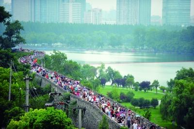 　　昨天,數(shù)萬南京市民參加“環(huán)城七十里”徒步走,圖為解放門城墻上密集的人群。 本版攝影 實習生 王甜