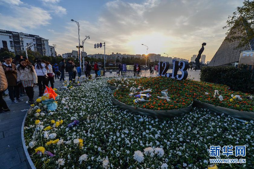 12月14日,觀眾在侵華日軍南京大屠殺遇難同胞紀(jì)念館前的“12·13”花壇上擺放鮮花祭奠遇難同胞。新華社記者 沈鵬 攝