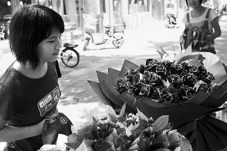 鄭州市農(nóng)業(yè)路一家花店擺放的玫瑰花吸引著一位過往女孩。