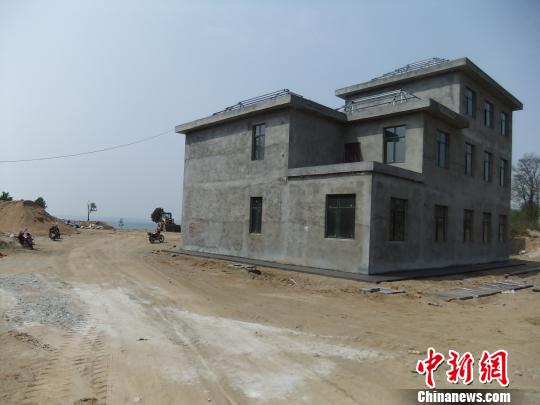 鴨河水庫(kù)庫(kù)區(qū)邊的新建別墅，一面墻上寫著“拆”，另一邊在加緊施工。吳揚(yáng)　攝